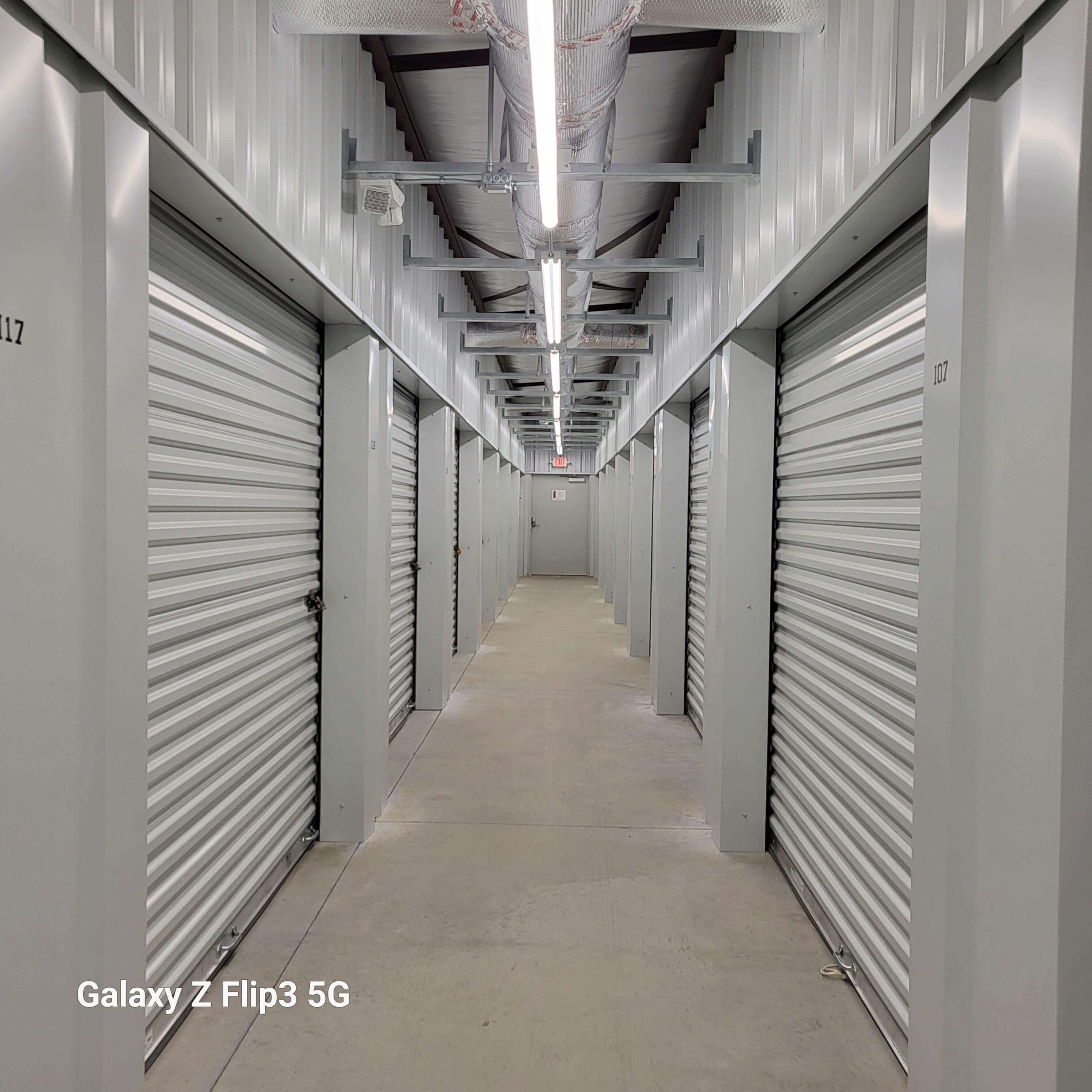 A well-organized and secure self-storage facility featuring rows of storage units with various sizes and configurations. Each unit is equipped with sturdy locks and surveillance cameras for added security. The facility is clean and well-maintained, with wide aisles for easy access. The signage prominently displays the name of the self-storage company and its contact information. This image showcases the ideal self-storage solution for individuals and businesses looking for safe and convenient storage options